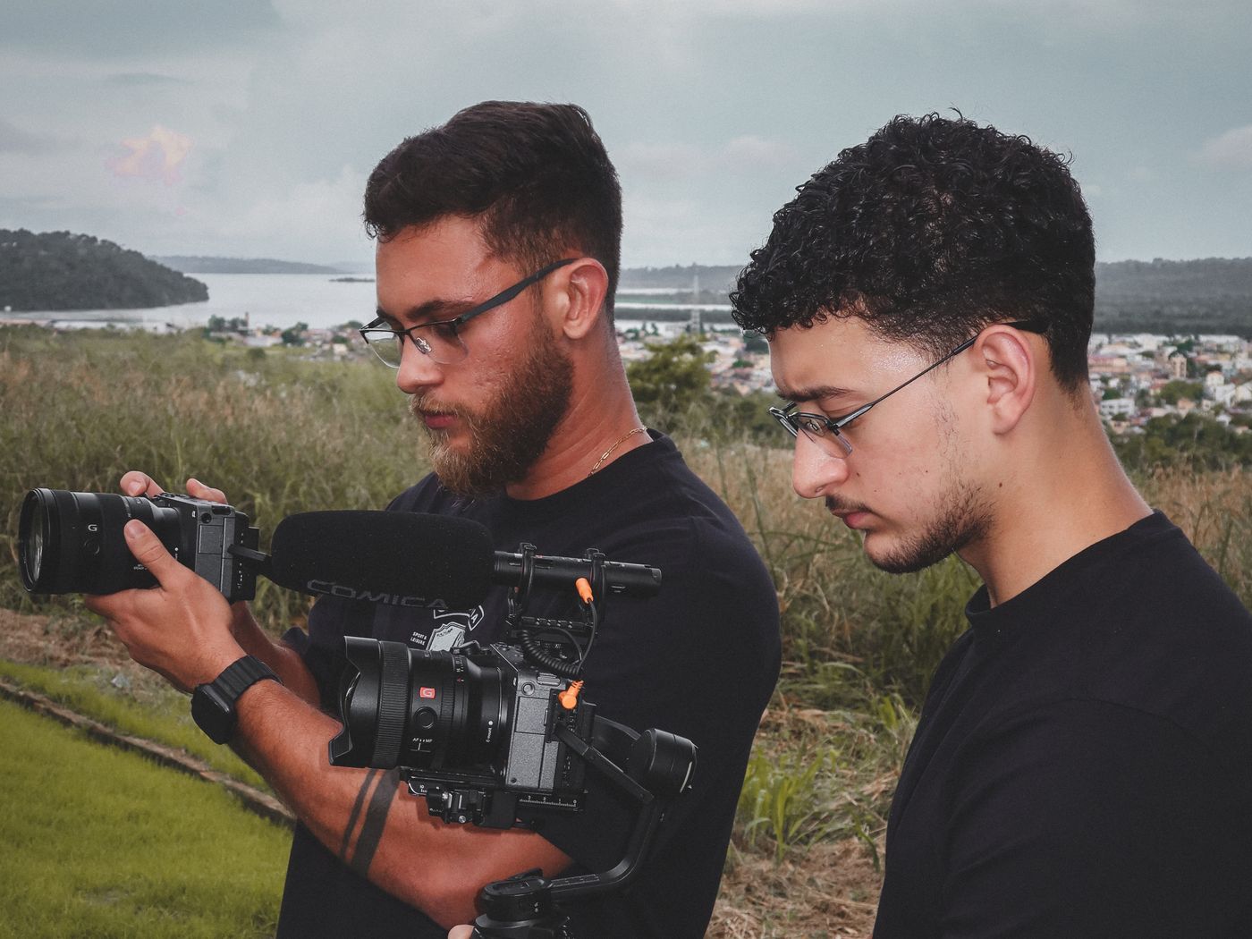 Matheus Castro e Gabriel Fischer filmando juntos, com câmera e estabilizador